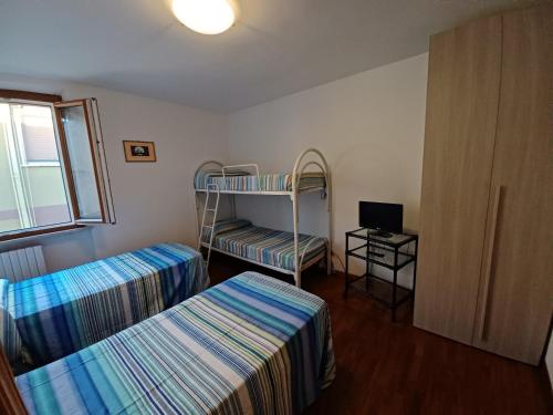 サン・ベネデット・デル・トロントにあるAppartamento Feliciaの二段ベッド2台、テレビが備わる客室です。