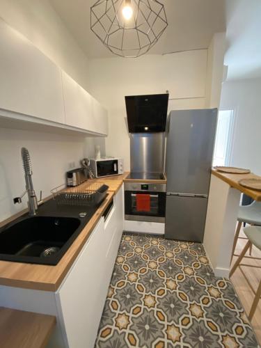 une cuisine avec un évier et un réfrigérateur dans l'établissement F2 Glamour Centre ville historique, à Ajaccio