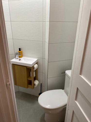 une salle de bain blanche avec des toilettes et un lavabo dans l'établissement F2 Glamour Centre ville historique, à Ajaccio