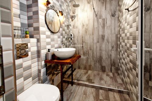 y baño con lavabo y espejo. en Wood&Steel Apartment, en Galaţi