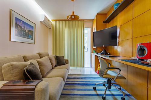 a living room with a couch and a tv at Premier Residence in Brasília