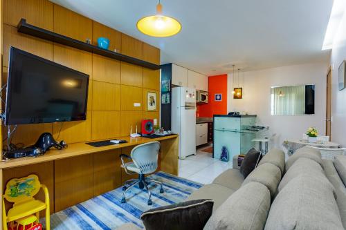 a living room with a large couch and a kitchen at Premier Residence in Brasília