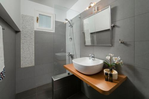 a bathroom with a sink and a mirror at Victoria's Summerhouse in Andros