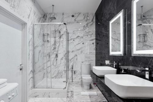 a bathroom with a shower and a sink and a toilet at Odesa Pearl Apartments in Odesa
