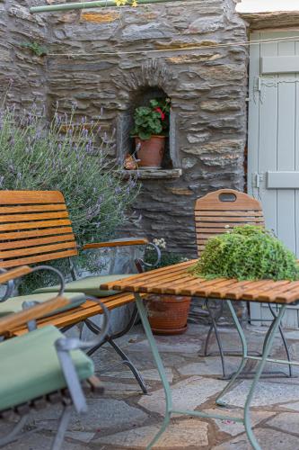 two benches and a table with plants on a patio at Victoria's Summerhouse in Andros