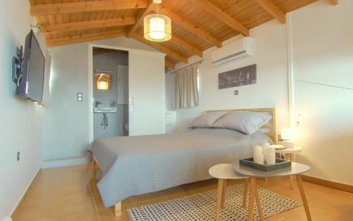 ein Schlafzimmer mit einem großen Bett und einem Tisch in der Unterkunft Augoustinos - Sea Side Luxury Apartments in Artemida