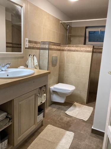 a bathroom with a sink and a toilet at Pommedi Apartman in Balatonalmádi