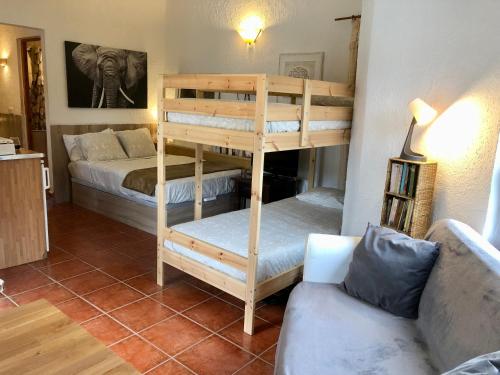 リョレート・デ・マルにあるCala Canyelles Holidays Apartmentsの二段ベッド2台とソファが備わる客室です。