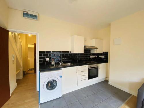 a kitchen with a washing machine and a sink at Cardiff simple and humble spacious 1-bed flat 1 mile to City Centre with basic furniture in Cardiff