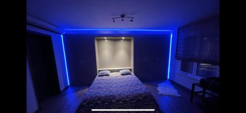 um quarto azul com uma cama com almofadas em B&B Les Plantees em Gorgier