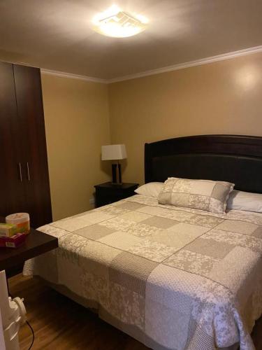 una camera con letto e tavolo con lampada di CASA VILLA AZUL 3 PISOS ad Antofagasta