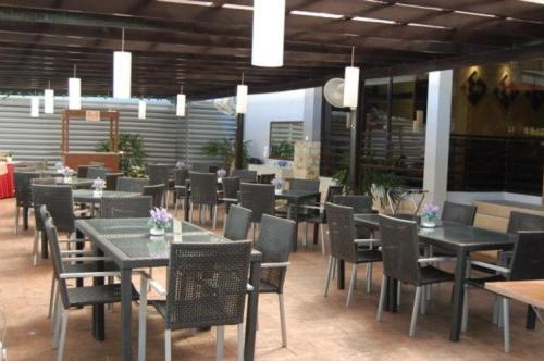 a dining room with tables and chairs in a restaurant at Hotel Seri Malaysia Kangar in Kangar