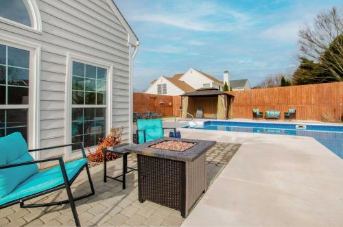 a patio with blue chairs and a table and a pool at Gorgeous Graham Home with Private Outdoor Pool! in Graham