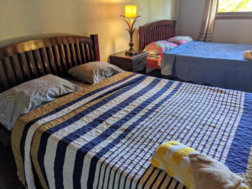 a bedroom with two beds with a blue and white blanket at Pool house, Casa Luna in Pavones