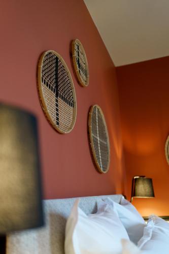 a bedroom with three plates on the wall at Hotel de la Plage in Lion-sur-Mer