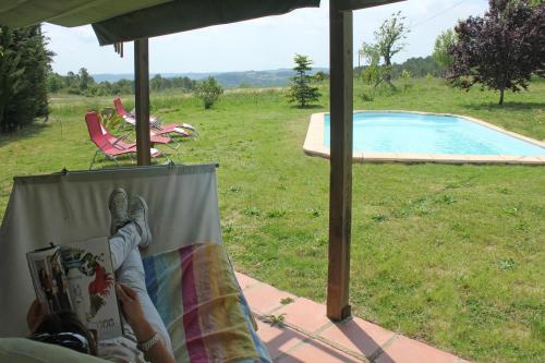 uma pessoa deitada numa cadeira ao lado de uma piscina em Mas La Casa Nova em Pontós