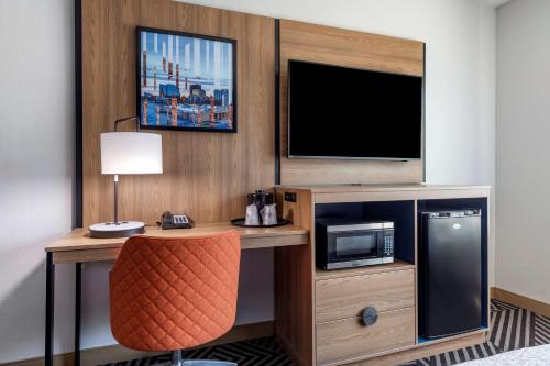 a room with a desk with a television and a chair at Best Western Plus Amarillo East Hotel in Amarillo