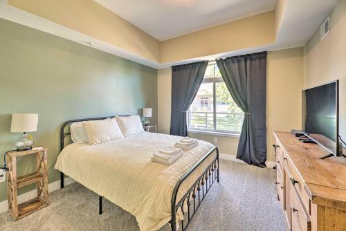 a bedroom with a bed and a flat screen tv at Grand Haven Condo - Walk to Nearby Hot Spots! in Grand Haven