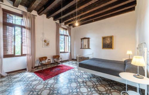 a bedroom with a bed and two chairs and windows at Il Barco Degli Alidosio in Sarcedo