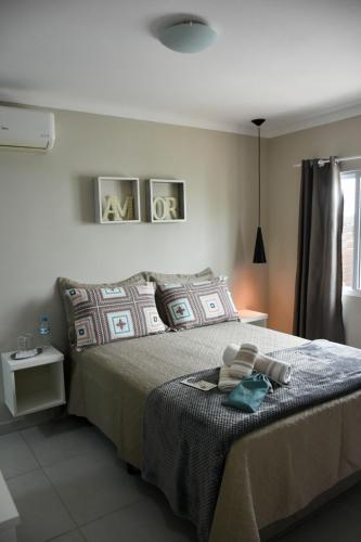 a bedroom with a bed with two towels on it at Pérola de Bombinhas in Bombinhas