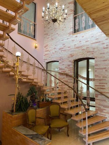 a lobby with stairs and chairs and a chandelier at Hotel and Restaurant "VILLA GIVISI" in Lagodekhi