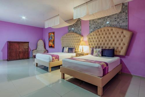 Hotel Lavanda CAS Merida في ميريدا: غرفة نوم بسريرين وجدران ارجوانية