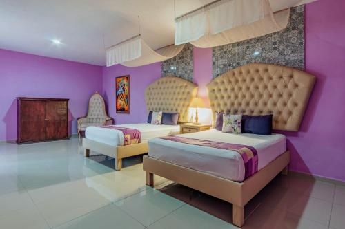 una camera con due letti e pareti viola di Hotel Lavanda CAS Merida a Mérida