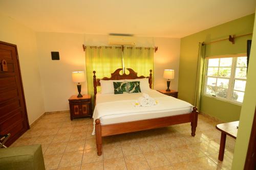 a bedroom with a bed and two lamps and a window at KikiWitz Resort in Belmopan