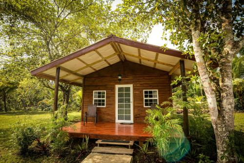 a small log cabin with a roof over a deck at KikiWitz Resort in Belmopan