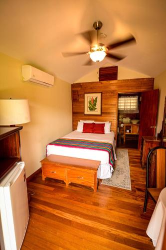 a bedroom with a bed and a ceiling fan at KikiWitz Resort in Belmopan