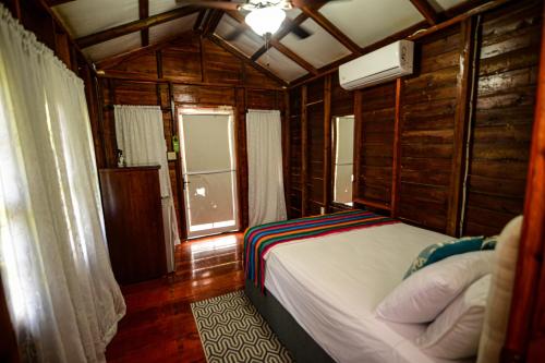 a bedroom with a bed in a room with a window at KikiWitz Resort in Belmopan