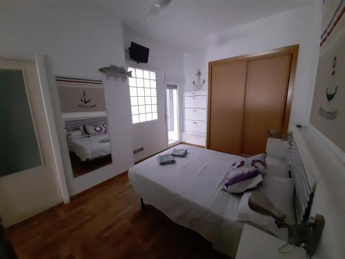 Un dormitorio con una cama grande y una ventana en Acogedor Bajo a 30 metros de la Playa, en Cala del Moral