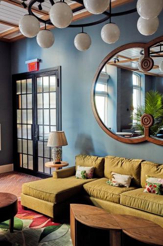 a living room with a couch and a mirror at The Drayton Hotel Savannah, Curio Collection by Hilton in Savannah