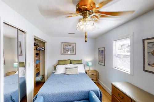 a bedroom with a blue bed and a ceiling fan at Crescent Beach Cottage in Saint Augustine