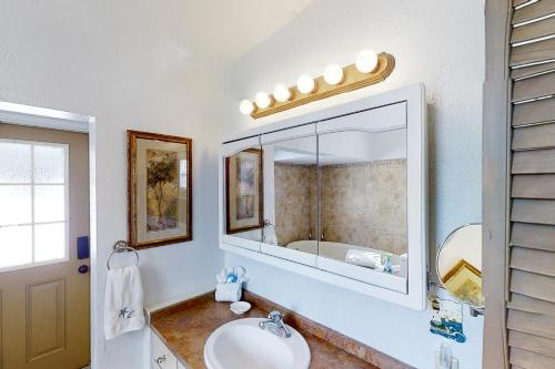 聖奧古斯丁的住宿－Crescent Beach Cottage，一间带水槽和镜子的浴室