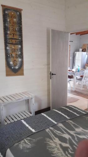 a room with a bed and a door and a table at Cabaña de las mariposas in Tigre