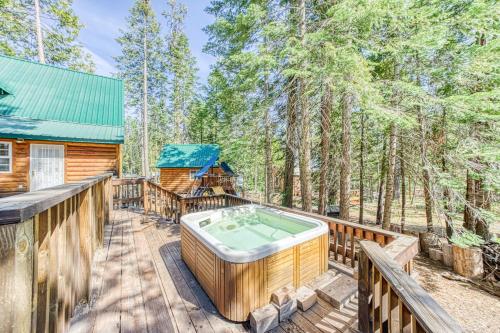 a hot tub on the deck of a cabin in the woods at Musick Creek Landing in Shaver Lake