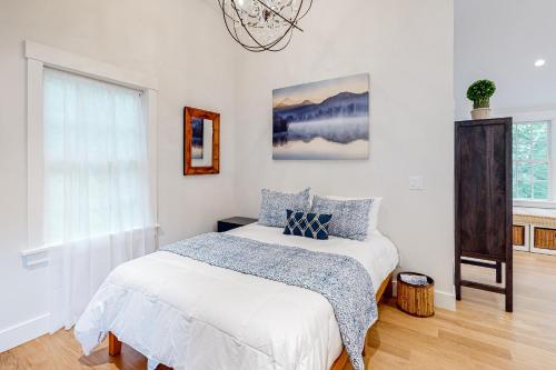 a white bedroom with a bed and a window at Coveside Carriage House in Boothbay Harbor