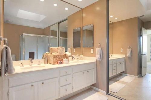 a bathroom with two sinks and a shower at Private Country Club Condo on awesome golf course! in Palm Desert