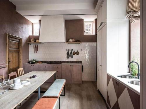 a kitchen with a large wooden table and a sink at Stately 16-person manor farm in South Limburg in Schimmert