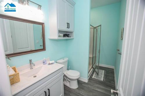 a bathroom with a sink and a toilet and a mirror at Kalm by the Beach - Ocean View - Sleeps 14 in Freeport