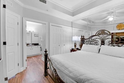 ein weißes Schlafzimmer mit einem großen Bett und einer Küche in der Unterkunft Calypso 2-2307 West in Panama City Beach