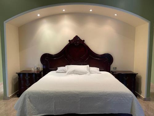 1 dormitorio con 1 cama grande y 2 mesitas de noche en Hotel la finca, en Ezequiel Montes