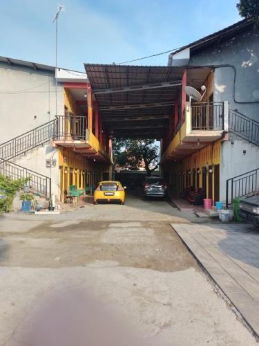een gele auto geparkeerd op een parkeerplaats naast een gebouw bij Near Jalan Tol 1 in Pekalongan