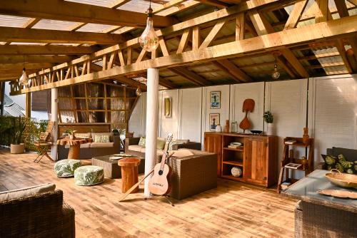 a living room with a guitar and a room with a couch at Hare Nua Hotel Boutique in Hanga Roa