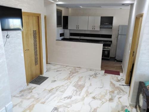 een keuken die gerenoveerd wordt met een marmeren vloer bij Appartement bien situé Dahomey city . Bahia beach in Bouznika