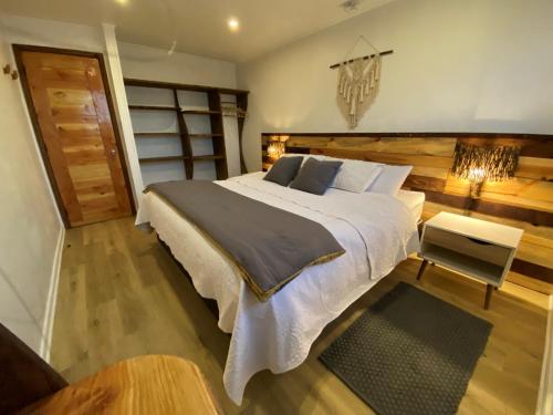 1 dormitorio con 1 cama grande y 1 mesa en Cabaña con tinaja en bosque Valdiviano en Valdivia