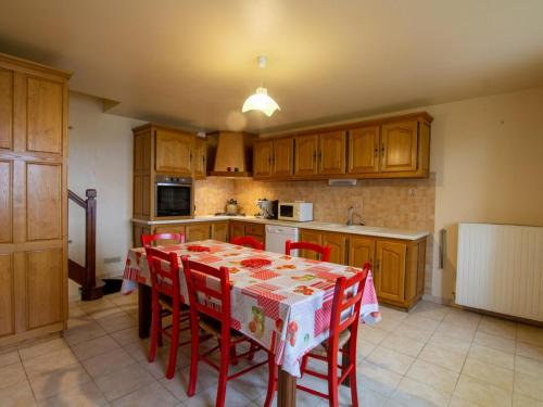 - une cuisine avec une table et des chaises rouges dans l'établissement Gîte avec jardin, jacuzzi, proche Sarlat et Lascaux, idéal pour familles et amis - FR-1-616-246, à Paulin
