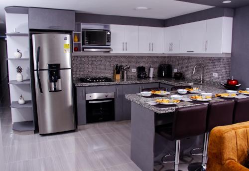 a kitchen with a refrigerator and a table with food on it at HERMOSO APARTAMENTO AMOBLADO CENTRO DE BUGA in Buga