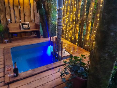 a swimming pool in a backyard with a bench and lights at Cabaña con tinaja en bosque Valdiviano in Valdivia
